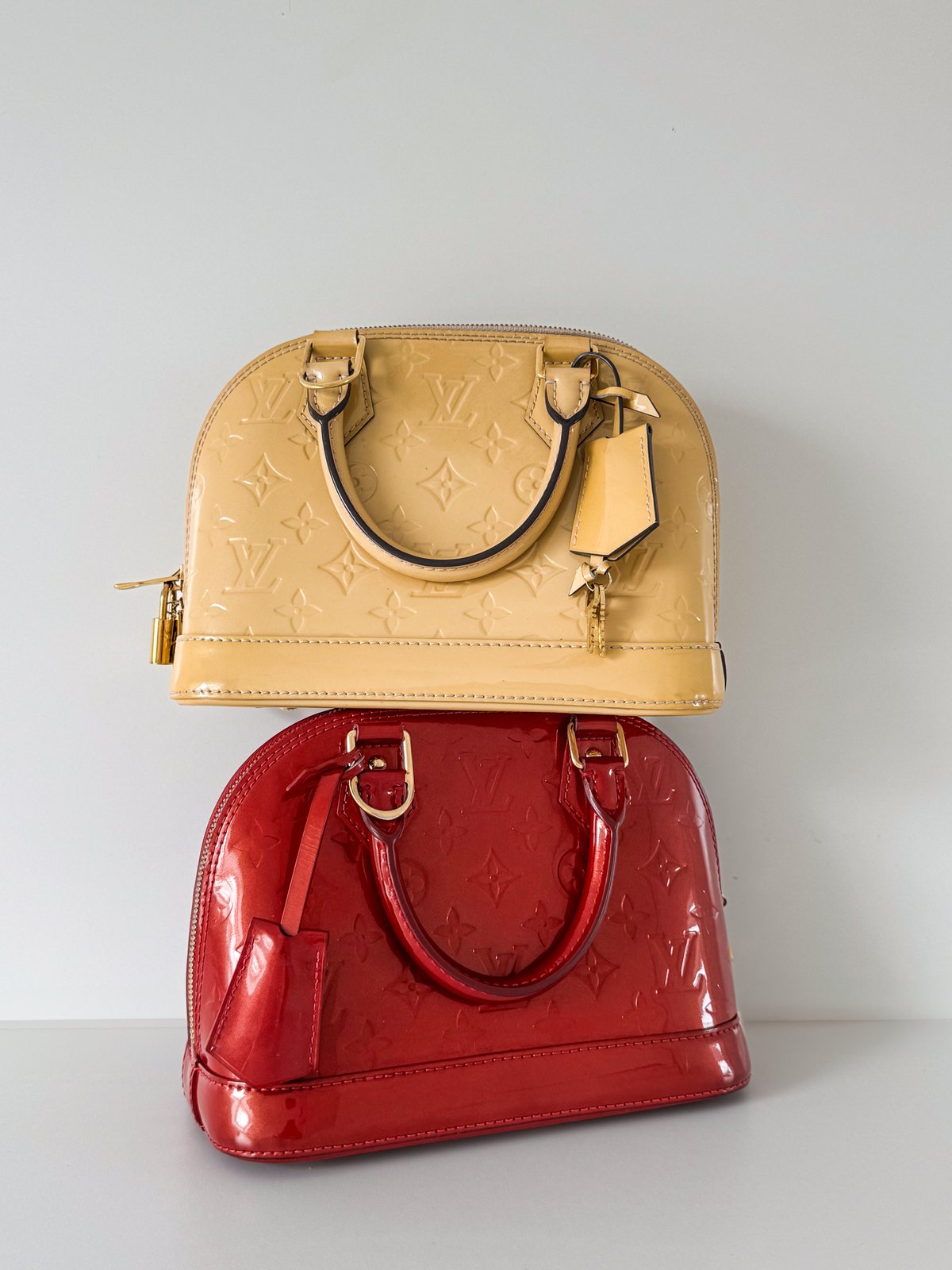 Zwei Louis Vuitton Alma übereinander auf hellem Grund